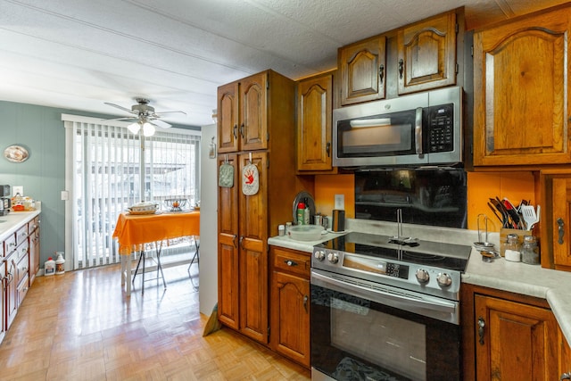 kitchen with light countertops, appliances with stainless steel finishes, and brown cabinets