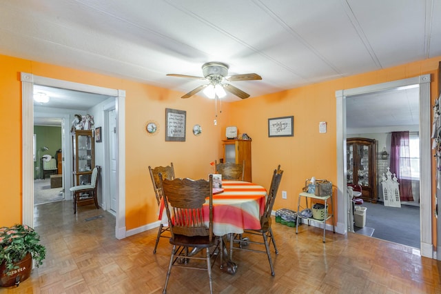 dining space with ceiling fan and baseboards