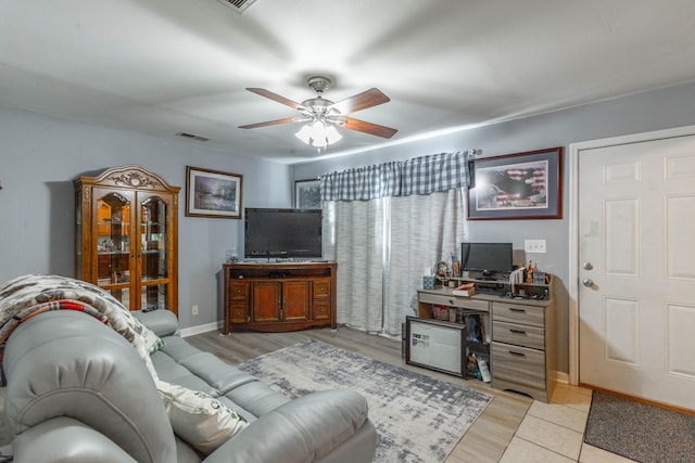 living area featuring a ceiling fan, light wood-type flooring, visible vents, and baseboards