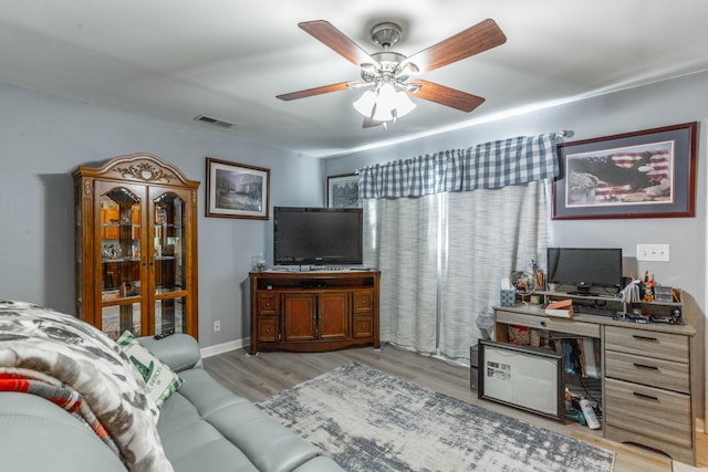 living area featuring a ceiling fan, visible vents, and wood finished floors