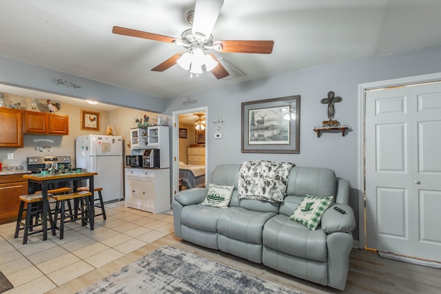 living room with light wood-type flooring and a ceiling fan