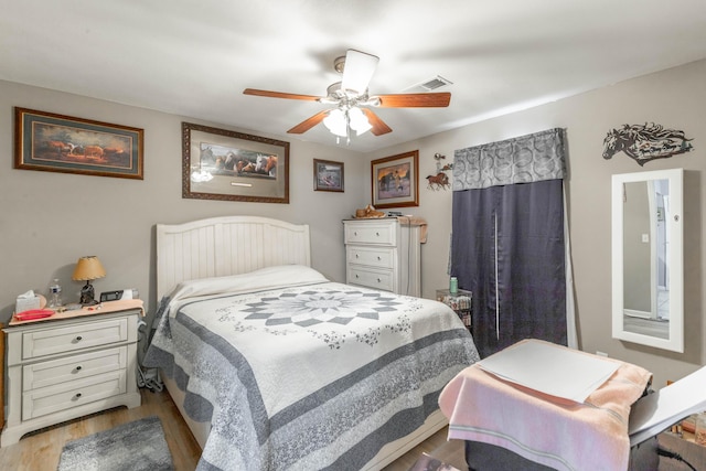 bedroom with visible vents, ceiling fan, and wood finished floors