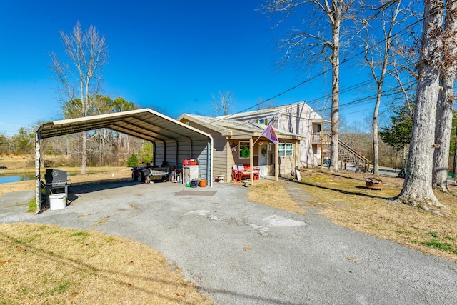 view of front facade featuring driveway, stairway, and a detached carport