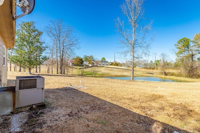 view of yard with a water view and central AC unit