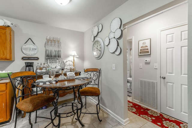 dining space featuring light tile patterned floors, baseboards, and visible vents