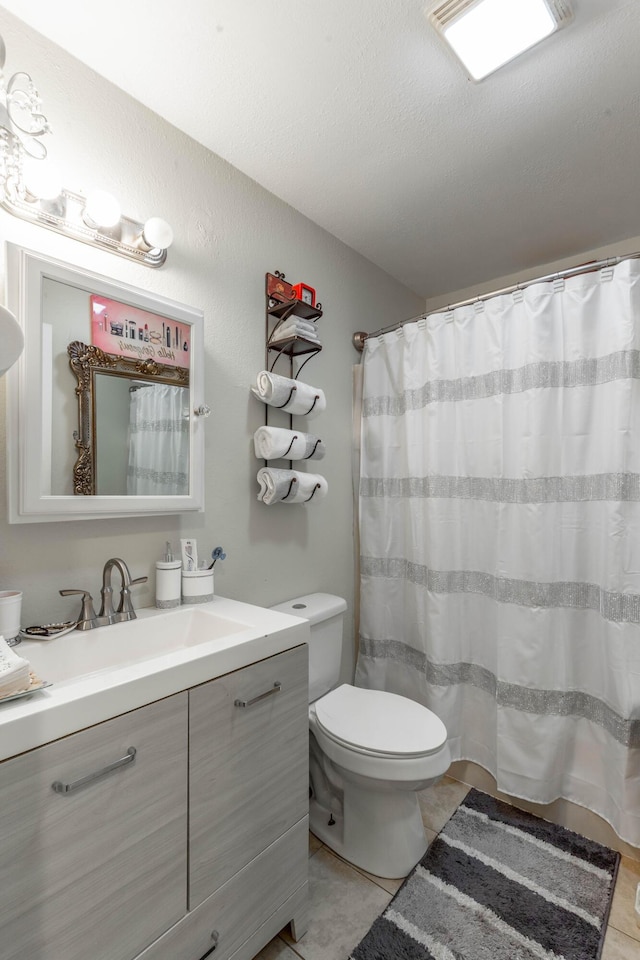 bathroom with a shower with curtain, vanity, toilet, and tile patterned floors