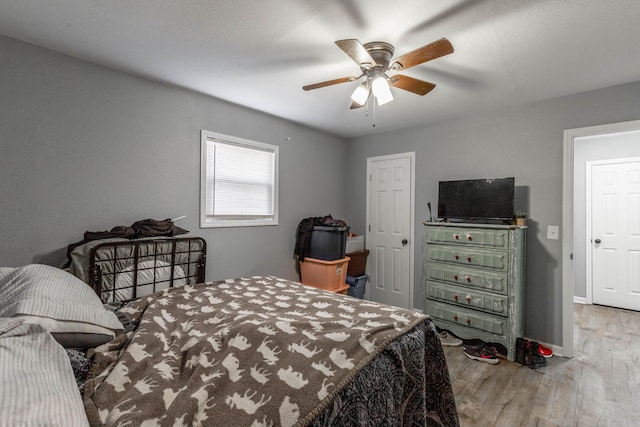 bedroom with ceiling fan, baseboards, and wood finished floors