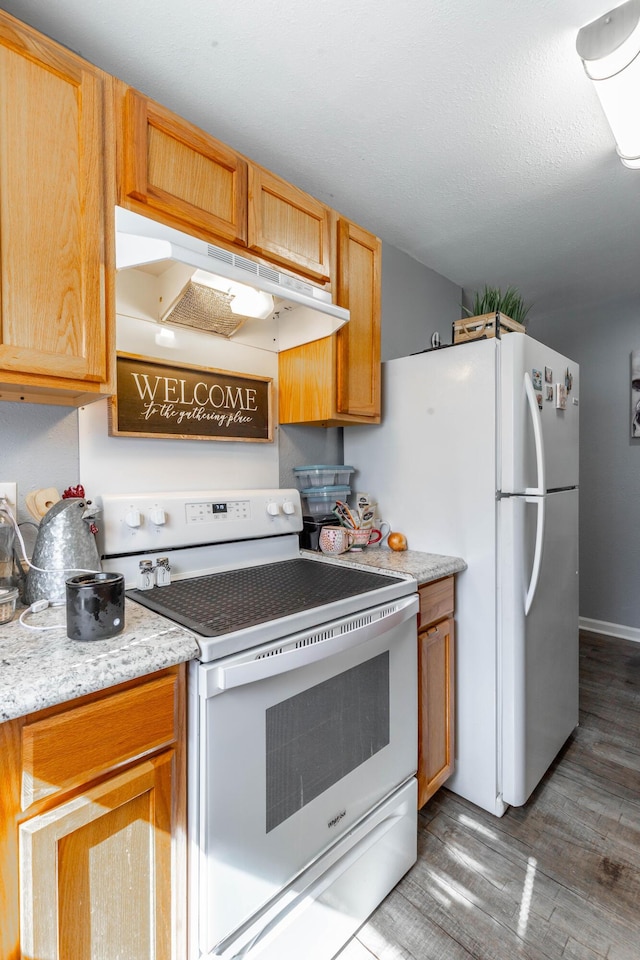 kitchen with white appliances, wood finished floors, and under cabinet range hood