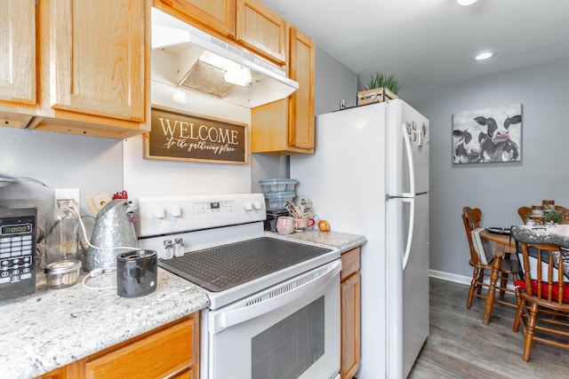 kitchen with white appliances, baseboards, light wood-style flooring, light brown cabinetry, and under cabinet range hood