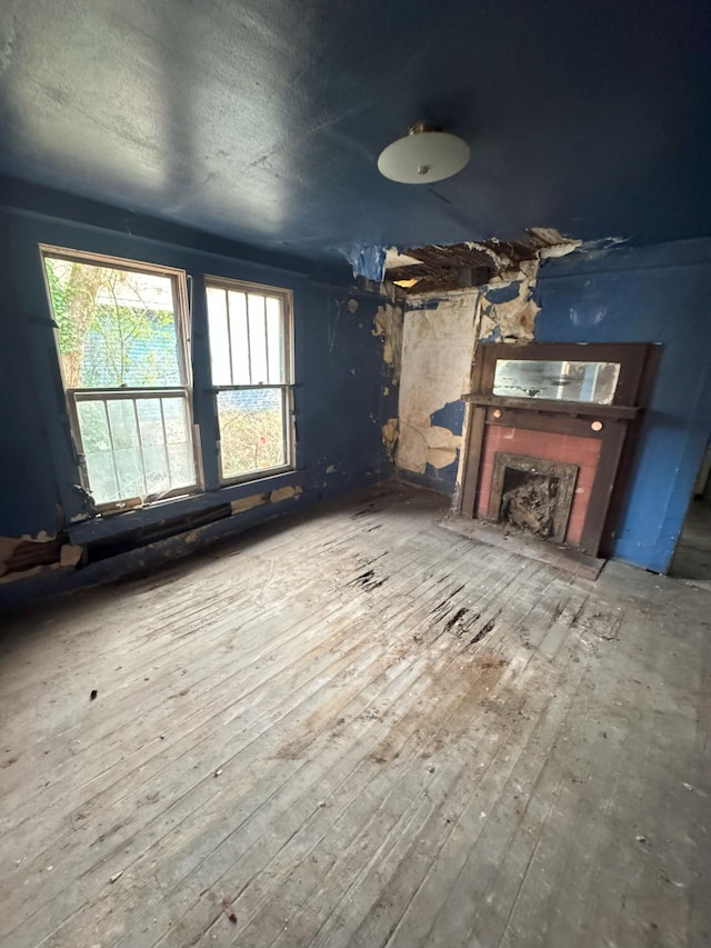 unfurnished living room with hardwood / wood-style flooring, a fireplace, and a textured ceiling