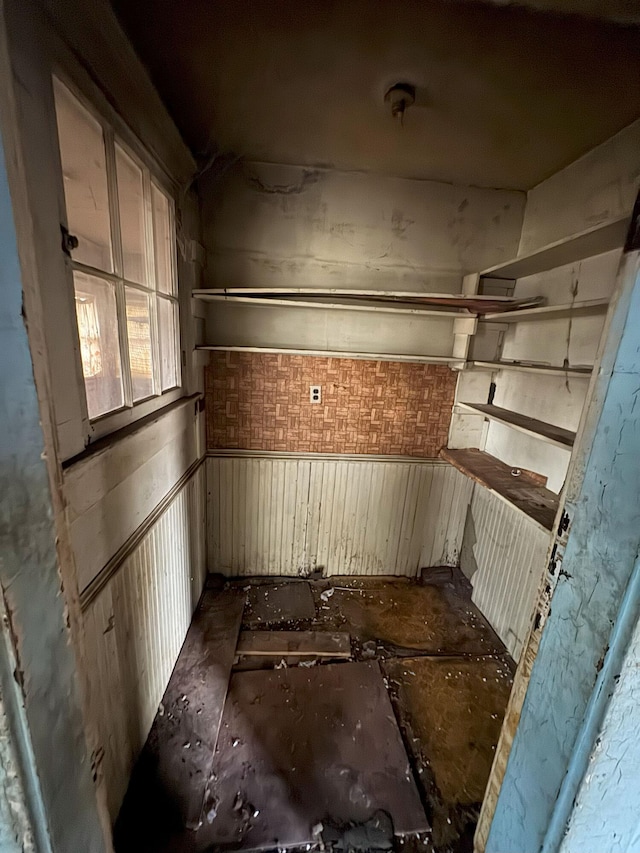 unfurnished room featuring a wainscoted wall