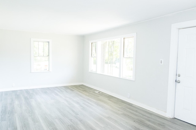 unfurnished room with light wood-type flooring and baseboards