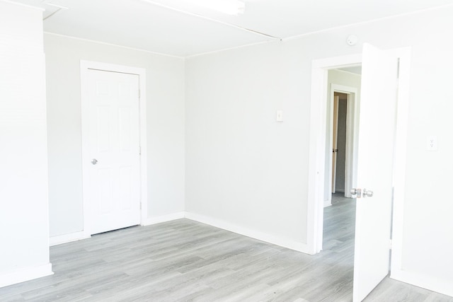 empty room featuring baseboards and light wood finished floors