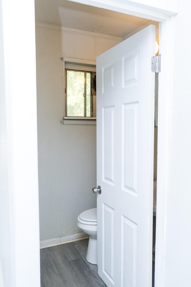 bathroom featuring ornamental molding, wood finished floors, and toilet