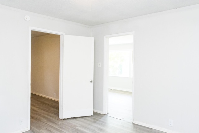 unfurnished room with baseboards and wood finished floors