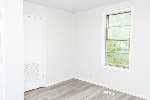 empty room featuring visible vents, light wood-style flooring, and baseboards