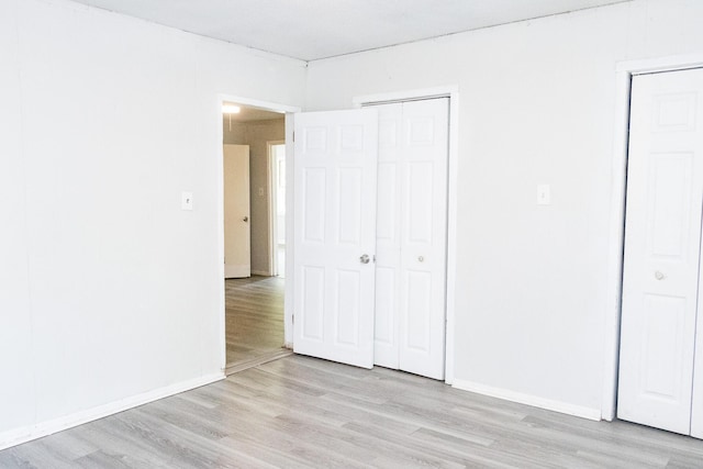 unfurnished bedroom with light wood-style floors and baseboards