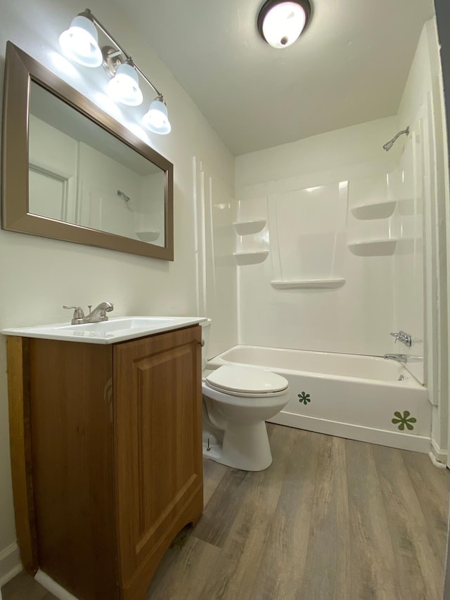 full bath with toilet, shower / washtub combination, wood finished floors, and vanity