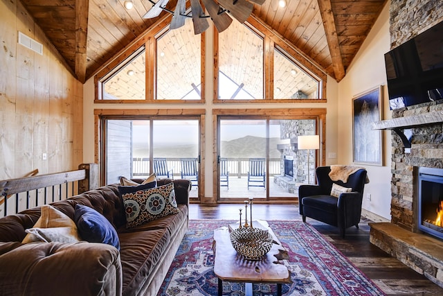 living room featuring wooden ceiling, a fireplace, visible vents, hardwood / wood-style floors, and beamed ceiling