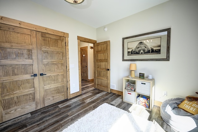 bedroom featuring wood finished floors, visible vents, and baseboards