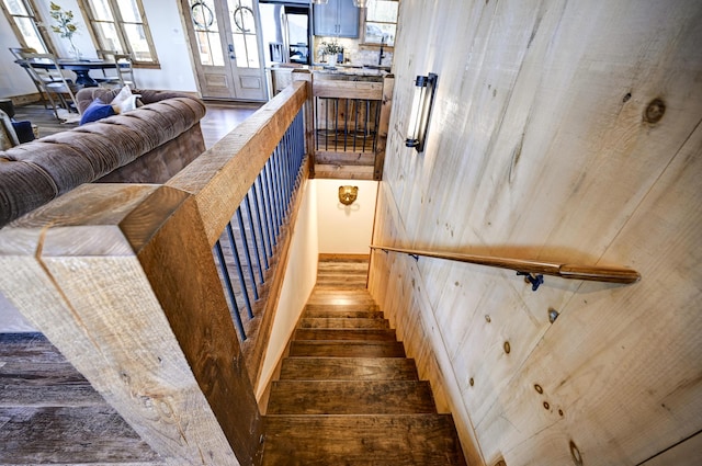 stairway with wood finished floors and french doors