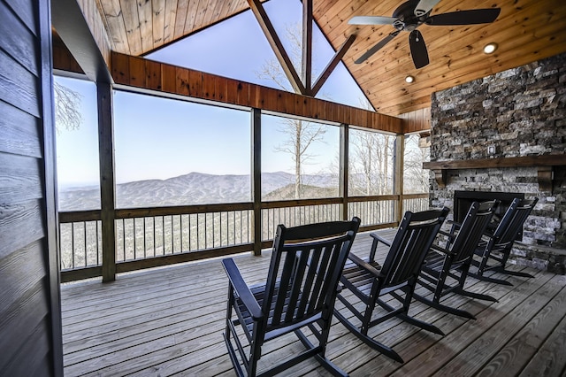 wooden deck featuring a mountain view, a fireplace, and a ceiling fan