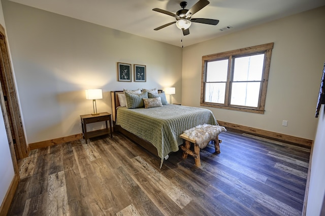 bedroom with a ceiling fan, visible vents, baseboards, and wood finished floors