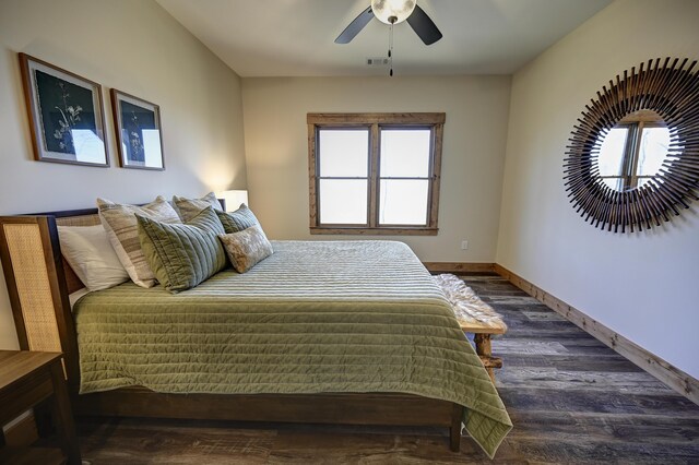 bedroom with ceiling fan, visible vents, baseboards, and wood finished floors