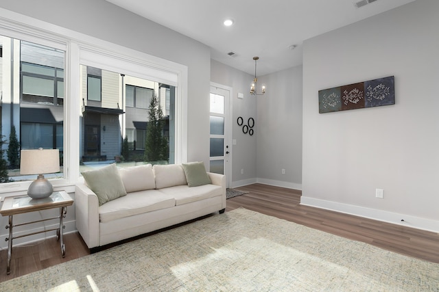 living room featuring recessed lighting, visible vents, wood finished floors, a chandelier, and baseboards