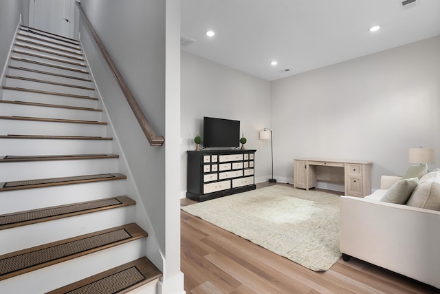 living area with baseboards, visible vents, wood finished floors, and recessed lighting