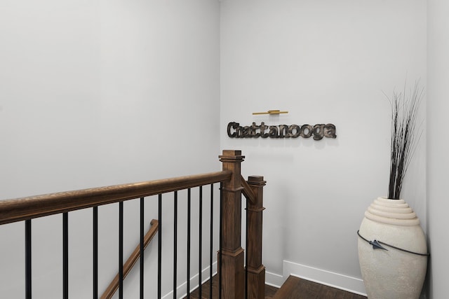 staircase featuring wood finished floors and baseboards