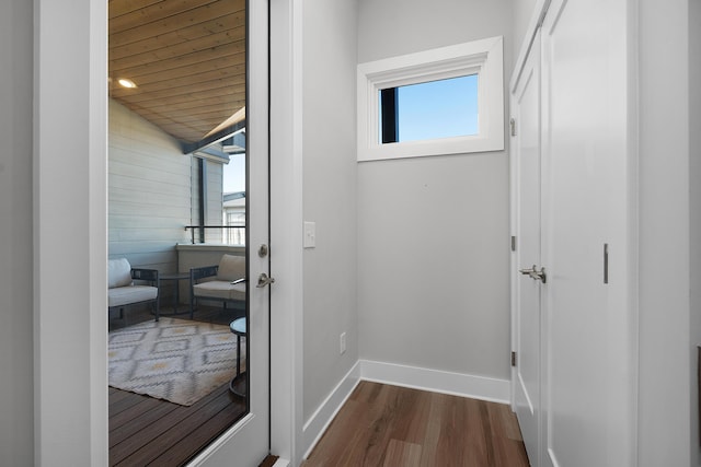 corridor with baseboards and dark wood-style flooring