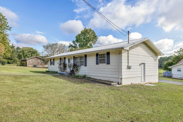 ranch-style house featuring metal roof and a front yard