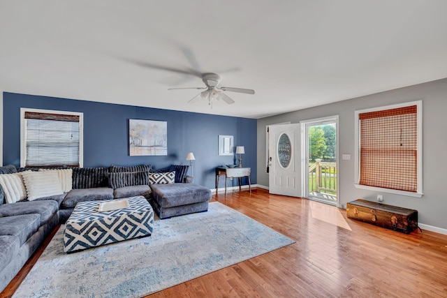 living area with ceiling fan, baseboards, and wood finished floors