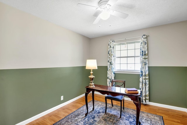 office featuring ceiling fan, a textured ceiling, wood finished floors, and baseboards