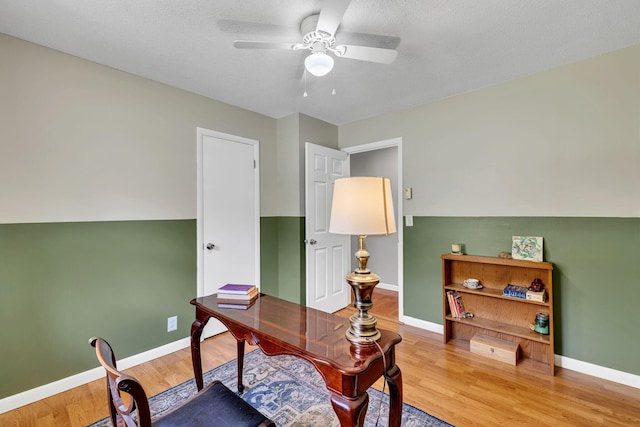 office with a ceiling fan, baseboards, and wood finished floors