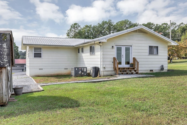 rear view of house featuring entry steps, metal roof, a yard, french doors, and crawl space