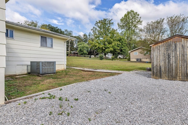 view of yard with central AC unit and an outdoor structure