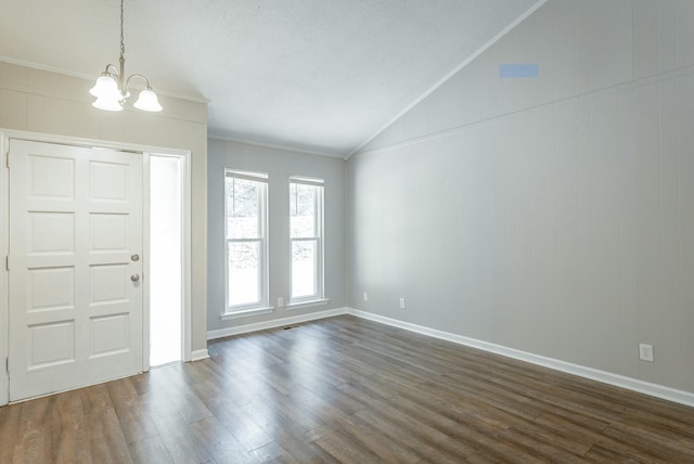 foyer entrance featuring crown molding, dark wood-style flooring, a notable chandelier, and vaulted ceiling