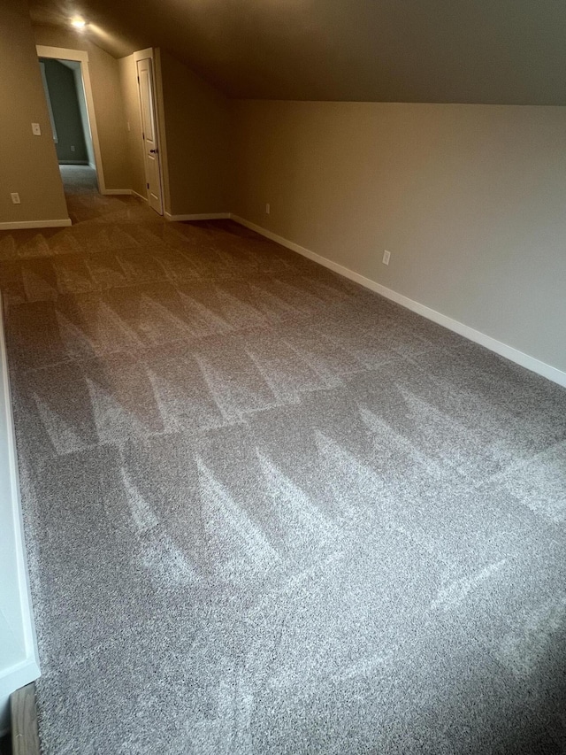 bonus room featuring carpet flooring, vaulted ceiling, and baseboards