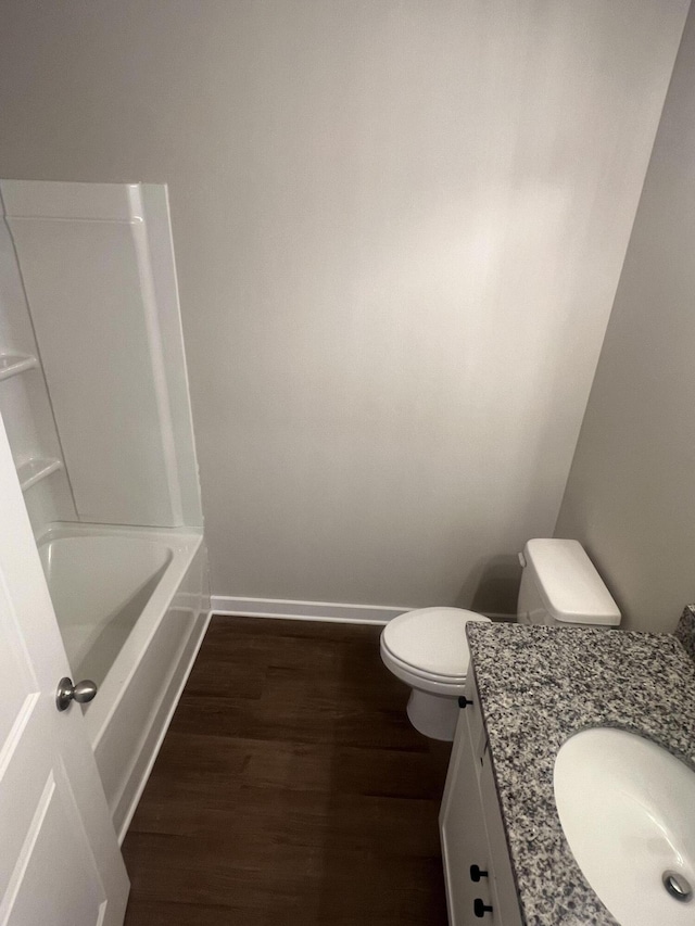 full bath featuring toilet, baseboards, wood finished floors, and vanity