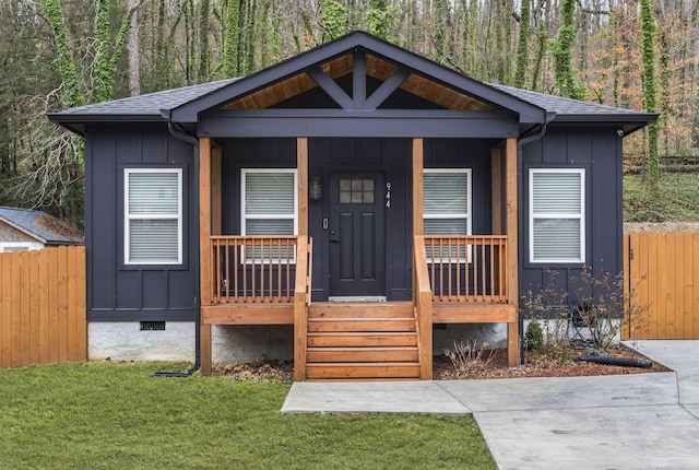 view of front of home with crawl space, board and batten siding, a porch, and fence