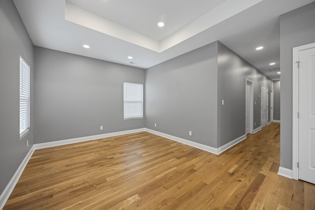 empty room featuring recessed lighting, baseboards, and light wood-style flooring