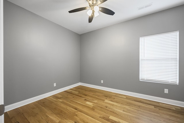 unfurnished room with visible vents, wood finished floors, baseboards, and ceiling fan