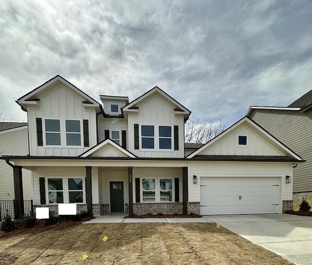 view of front of house with driveway, a porch, an attached garage, board and batten siding, and brick siding