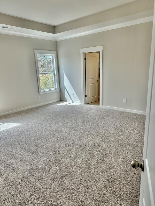 spare room with baseboards, carpet floors, and visible vents