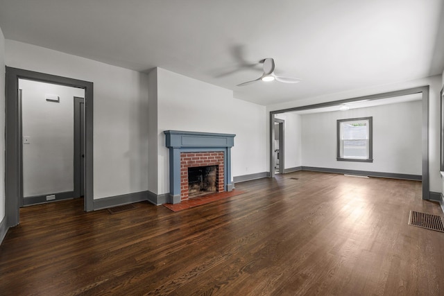 unfurnished living room featuring a ceiling fan, a fireplace, visible vents, and dark wood-style flooring