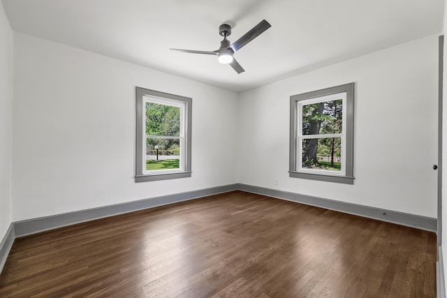 unfurnished room with dark wood-type flooring, baseboards, and a ceiling fan