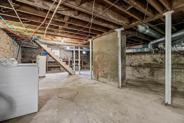 unfinished below grade area with stairway, washer and dryer, and electric water heater