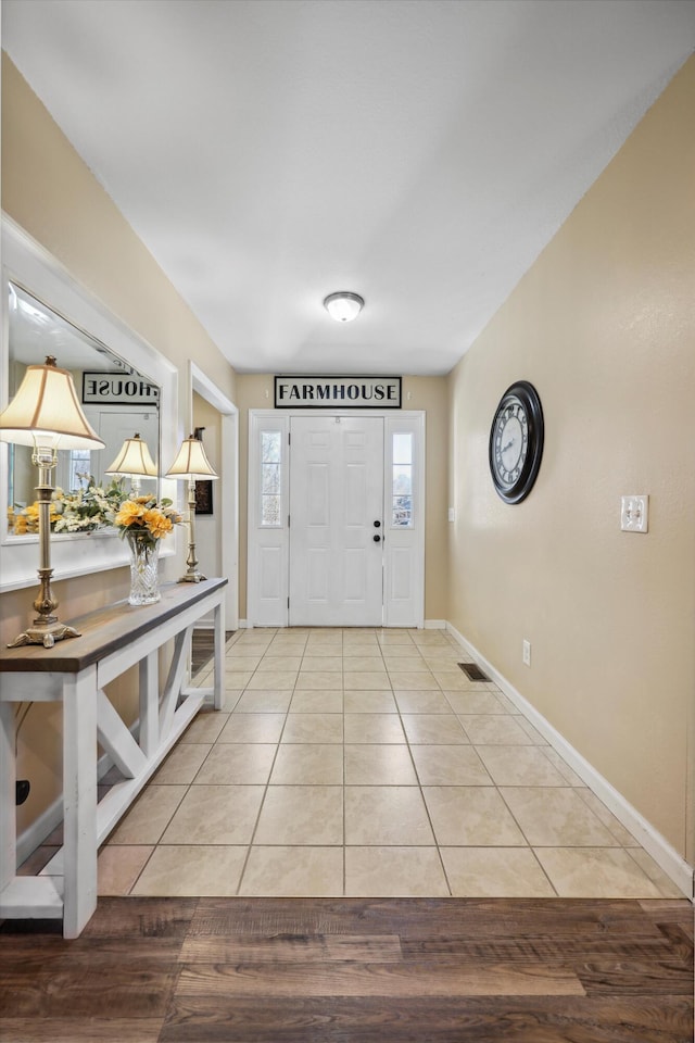 tiled foyer featuring visible vents and baseboards